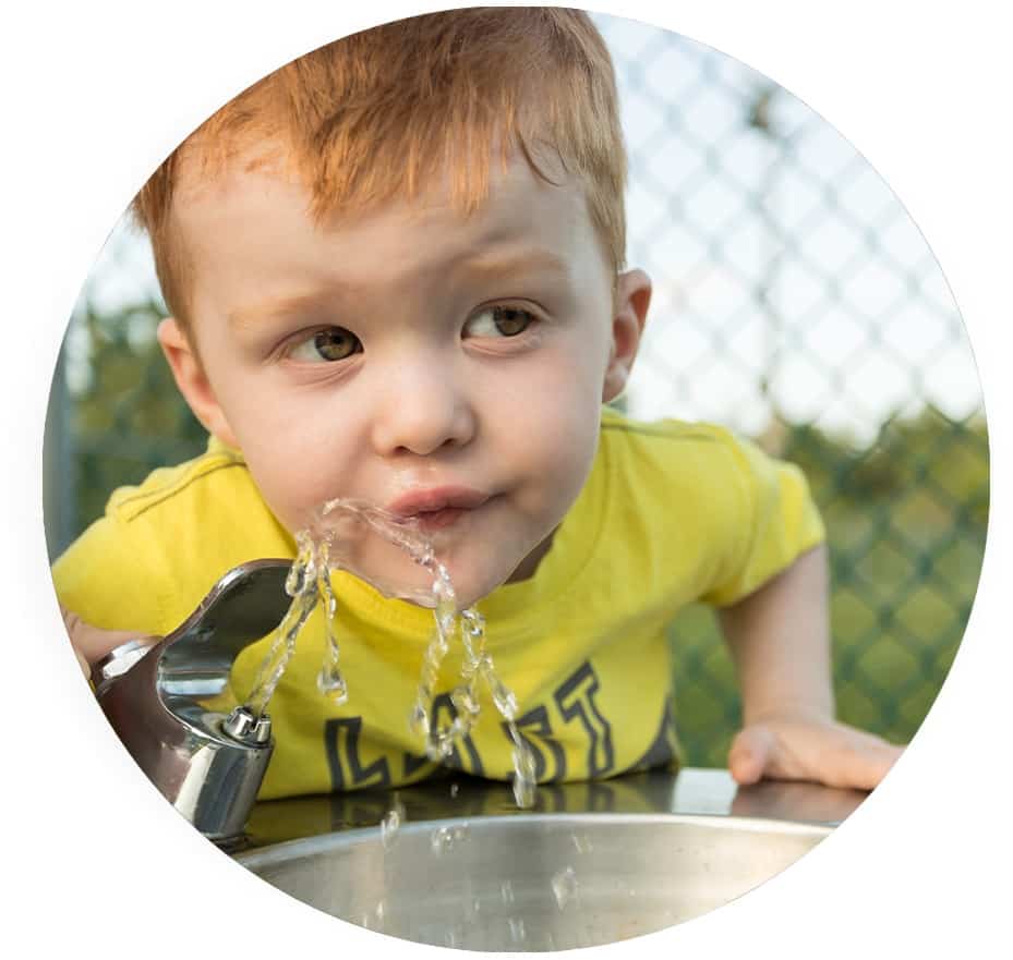 Boy drinking water from water fountain